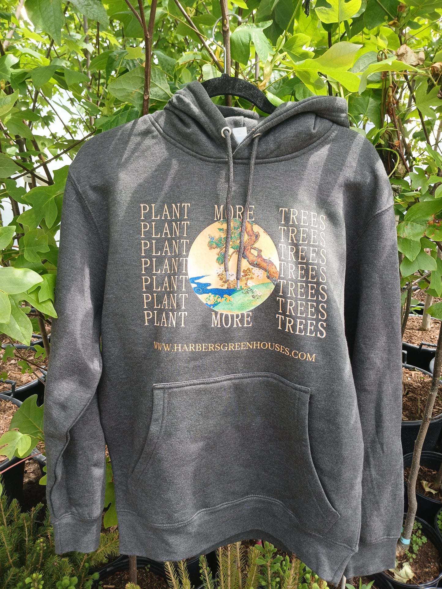 a photo of the coolest hoodie you've ever seen, hanging from a tree.